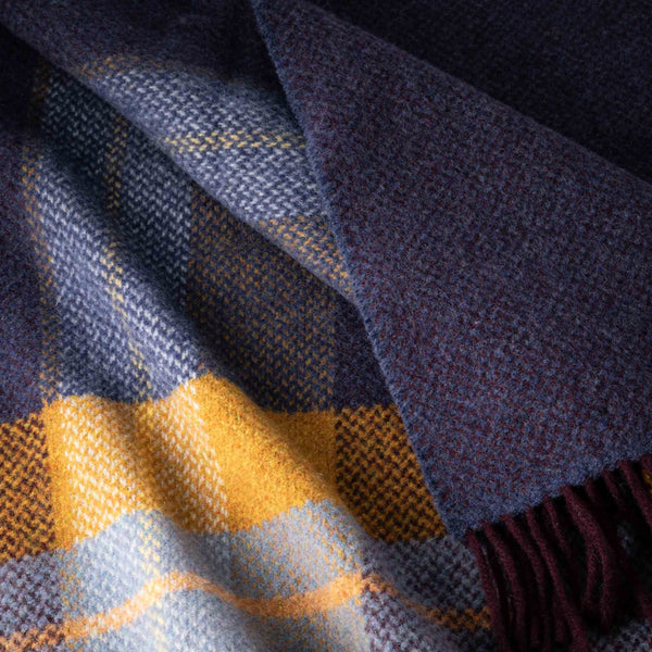 Close-up of a plaid fabric with blue, yellow, and purple colors.