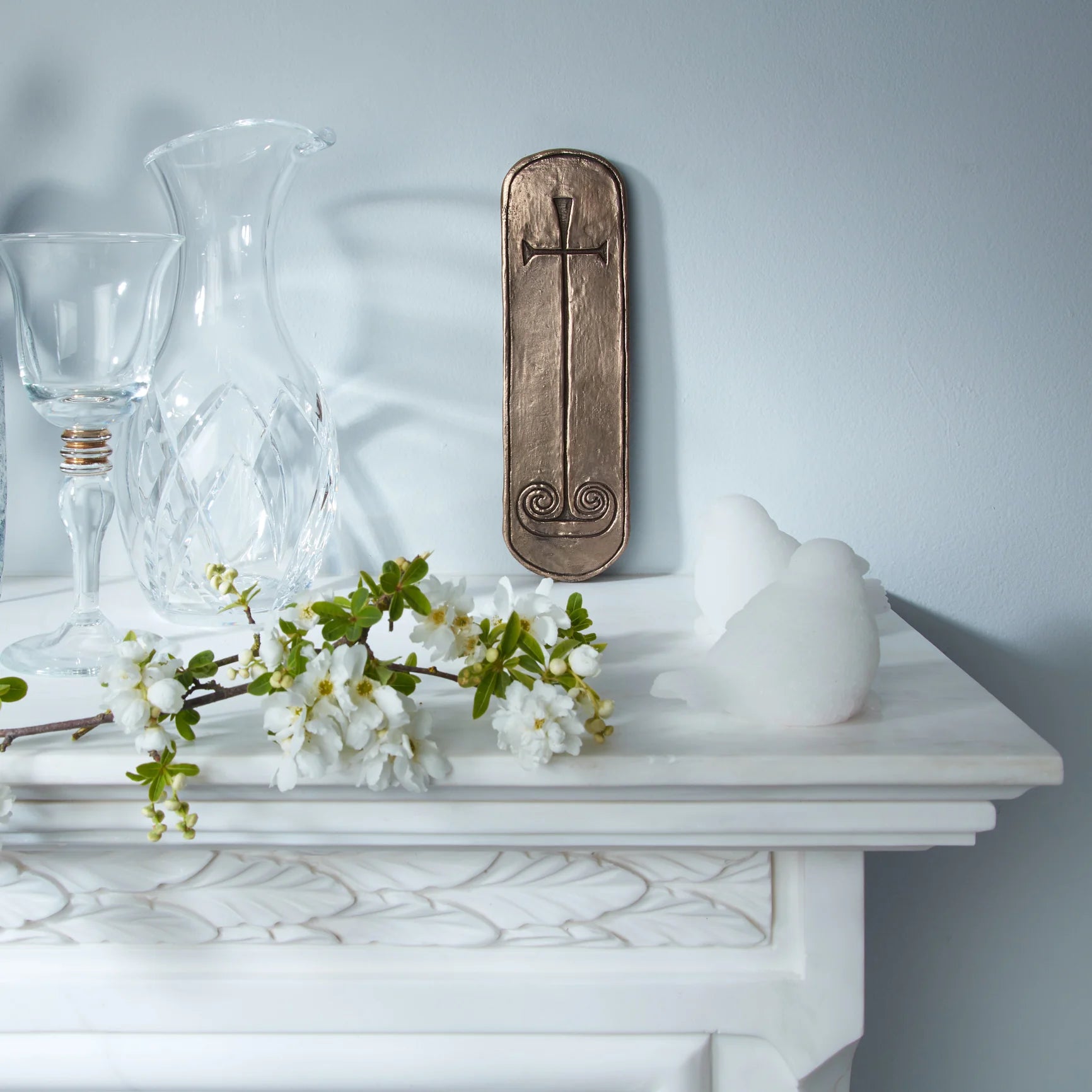 Decorative items including a vase, wine glass, and flowers on a white surface with a gray background.