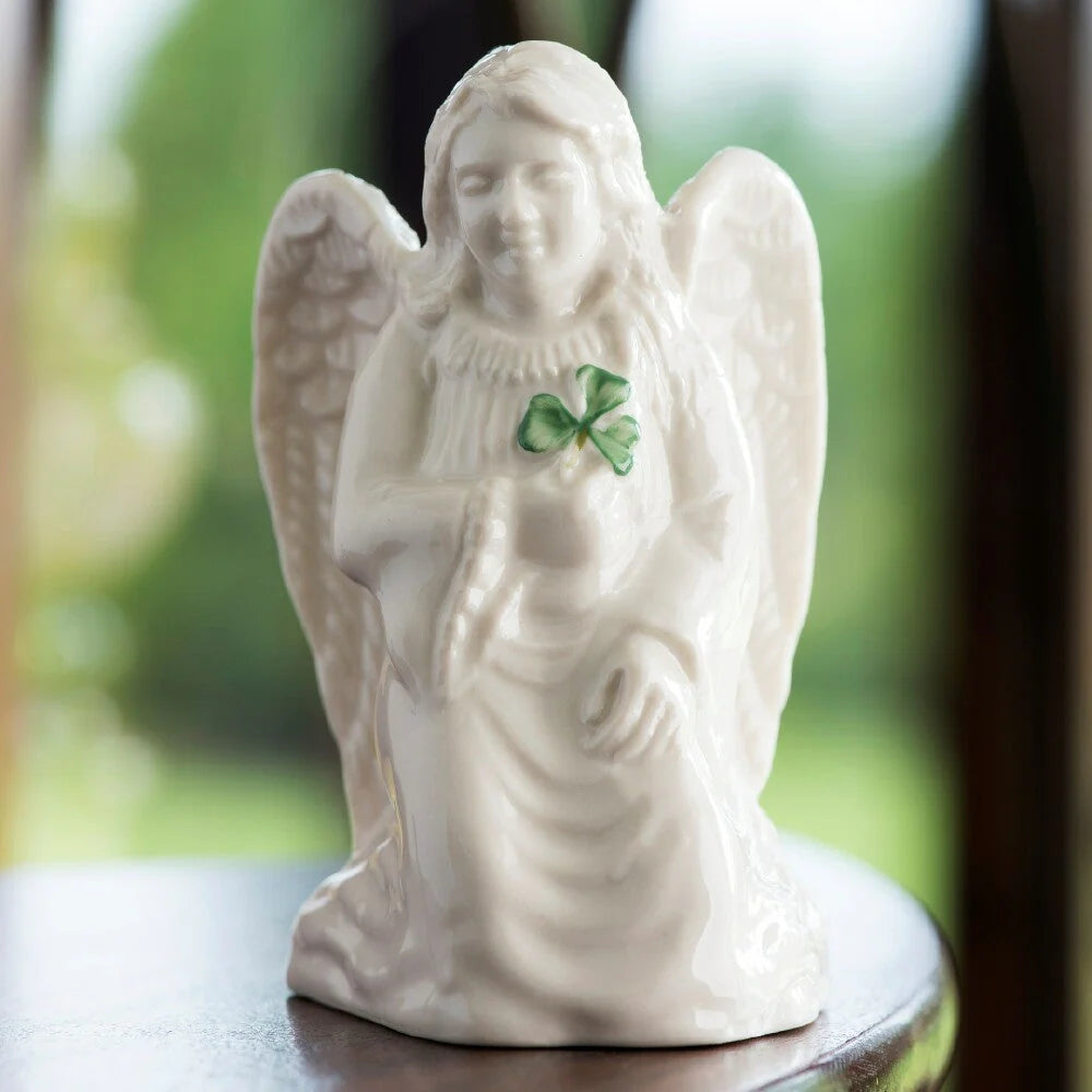 White angel figurine with a green shamrock on a blurred background