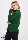 Woman wearing a green knitted sweater on a white background