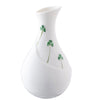 White vase with green clover designs on a white background