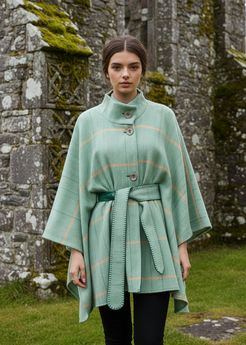 Woman wearing a Jimmy Hourihan green plaid poncho against a white background