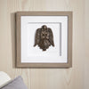 Framed artwork of a bronze angel sculpture on a wooden wall.