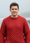 man wearing a redaran knitted sweater with a patterned design outdoors.