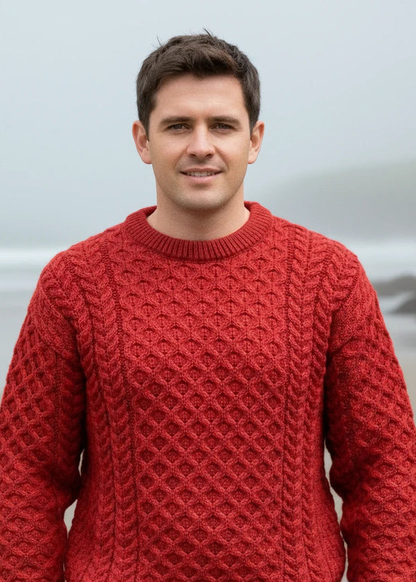 man wearing a redaran knitted sweater with a patterned design outdoors.