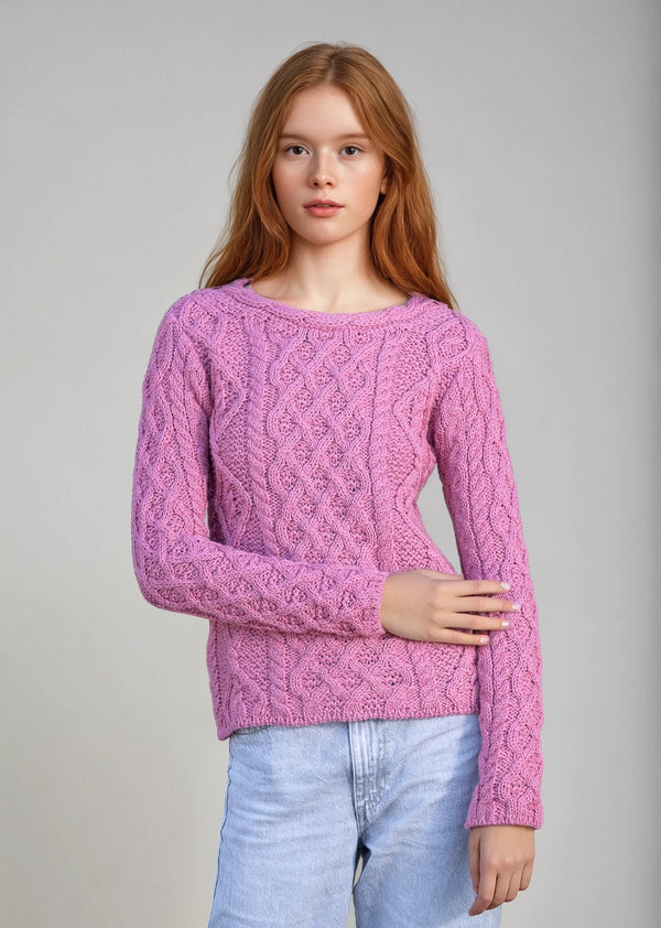 Woman wearing a pink knitted sweater against a gray background