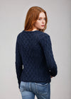 Woman wearing a dark blue cable knit sweater on a gray background
