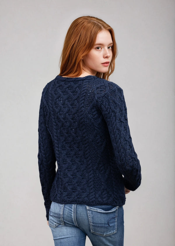 Woman wearing a dark blue cable knit sweater on a gray background