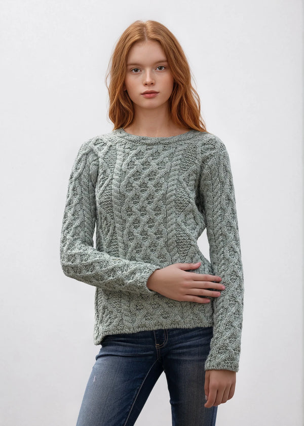 Woman wearing a green knitted sweater against a white background