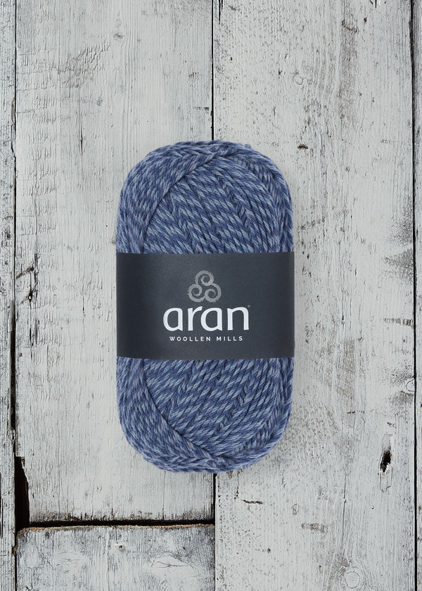 Blue yarn ball with 'aran' label on a wooden surface