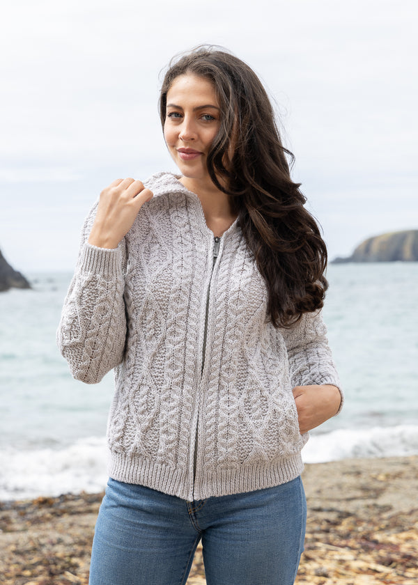 Woman wearing a beige cable knit sweater on a beach
