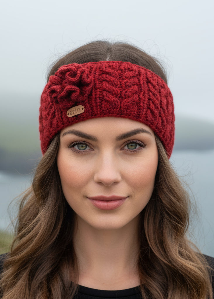 Red knitted aran headband with a flower on a white background