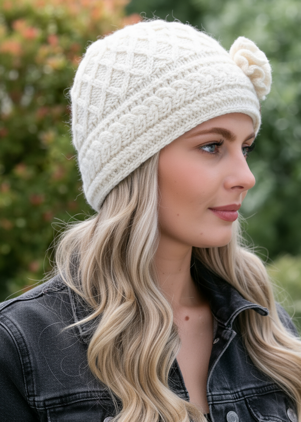 Woman wearing a white knit beanie with FLOWER.