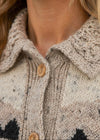 Close-up of a person wearing a patterned cardigan with buttons.