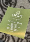 Aran Woollen Mills label on a textured fabric background