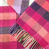 Close-up of a colorful plaid fabric with a scarf draped over it.