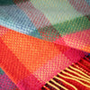 Close-up of a colorful plaid fabric with red, orange, green, and blue patterns.