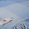 Blue blanket with a visible brand label on a soft focus background