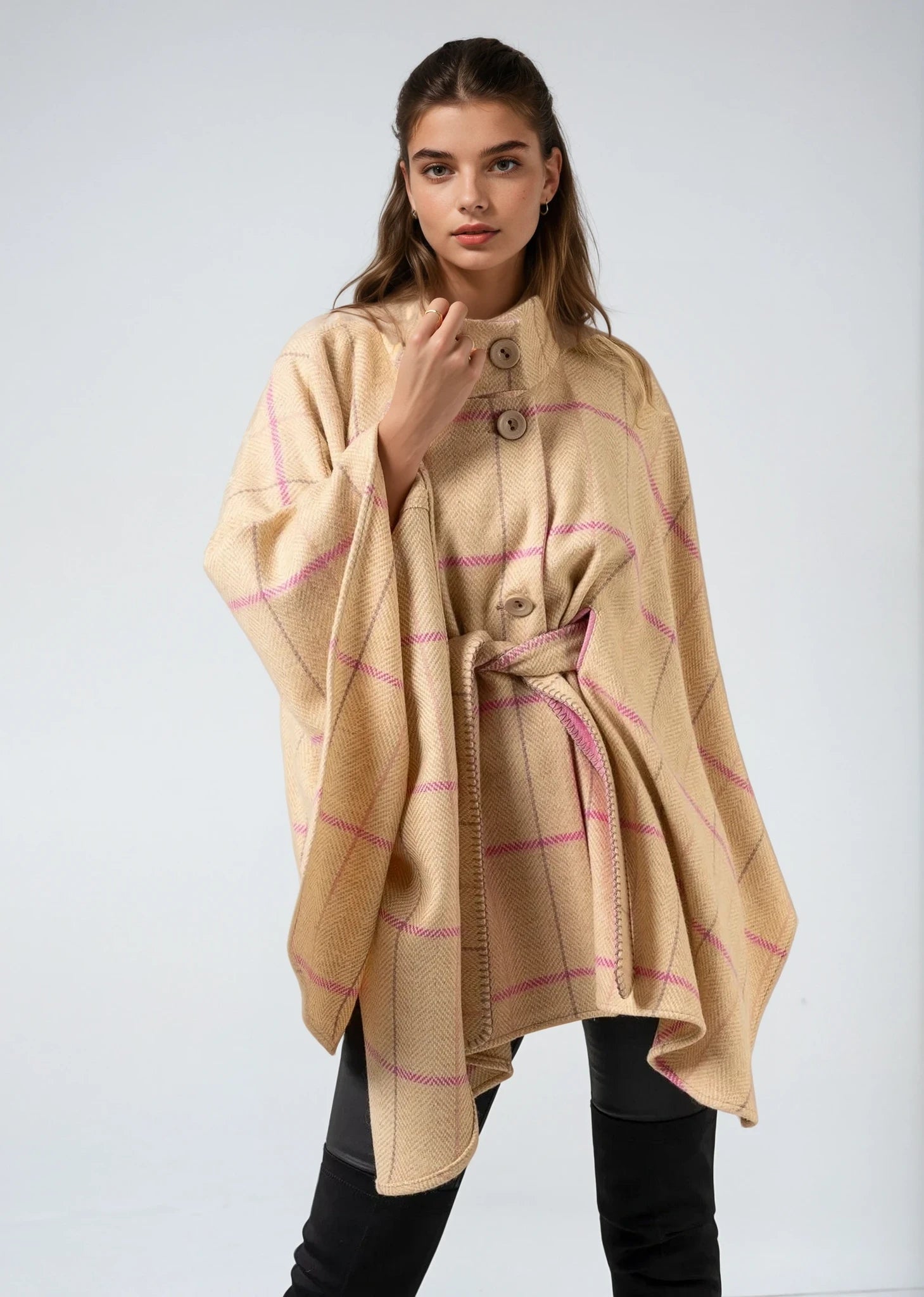 Woman wearing a Jimmy Hourihan beige and pink plaid poncho on a white background