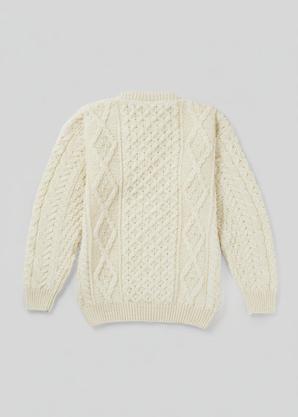 Cream-colored cable knit sweater on a light gray background
