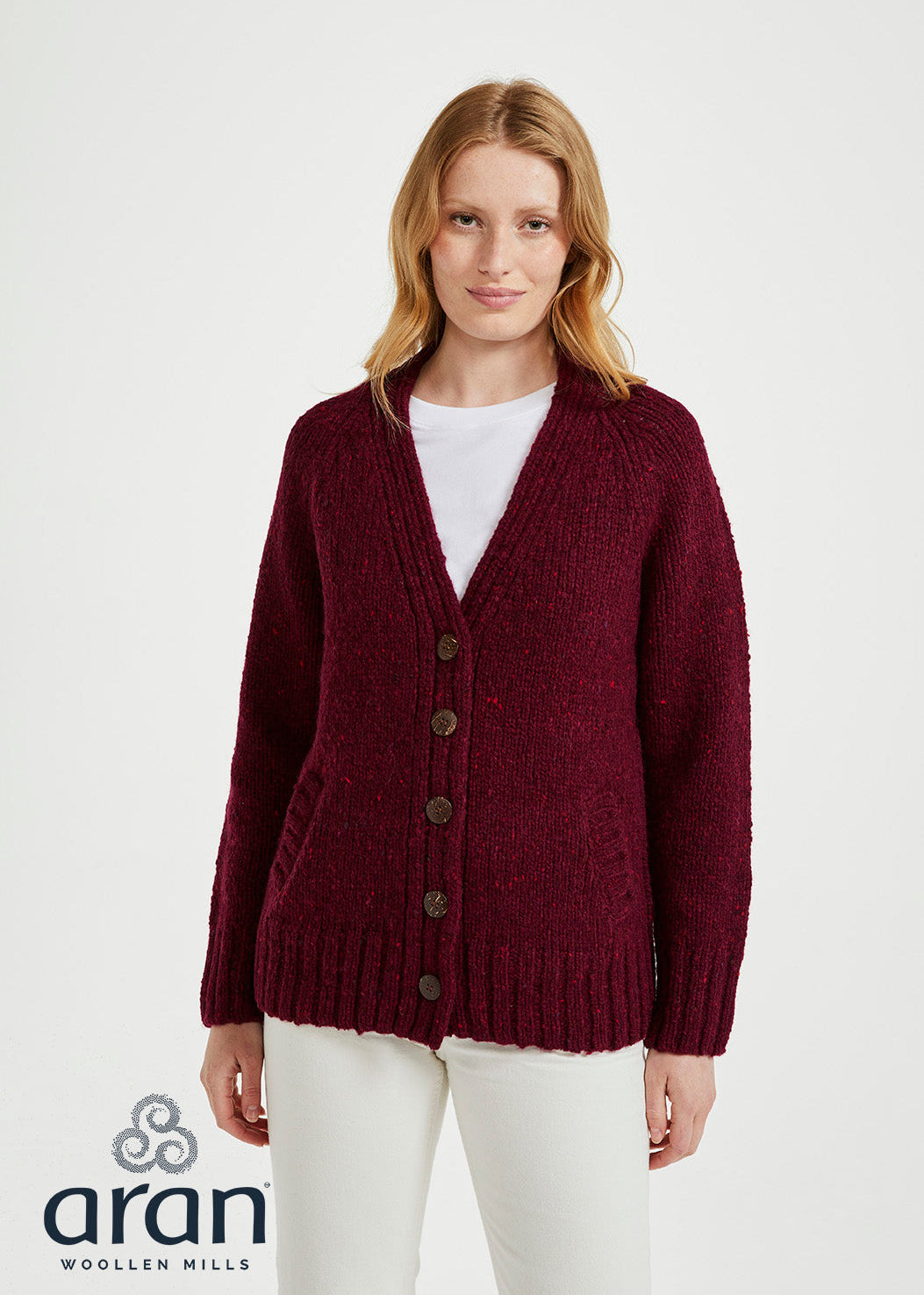 Woman wearing a burgundy cardigan over a white shirt on a white background, with Aran Woollen Mills logo.