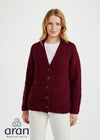 Woman wearing a burgundy cardigan over a white shirt on a white background, with Aran Woollen Mills logo.