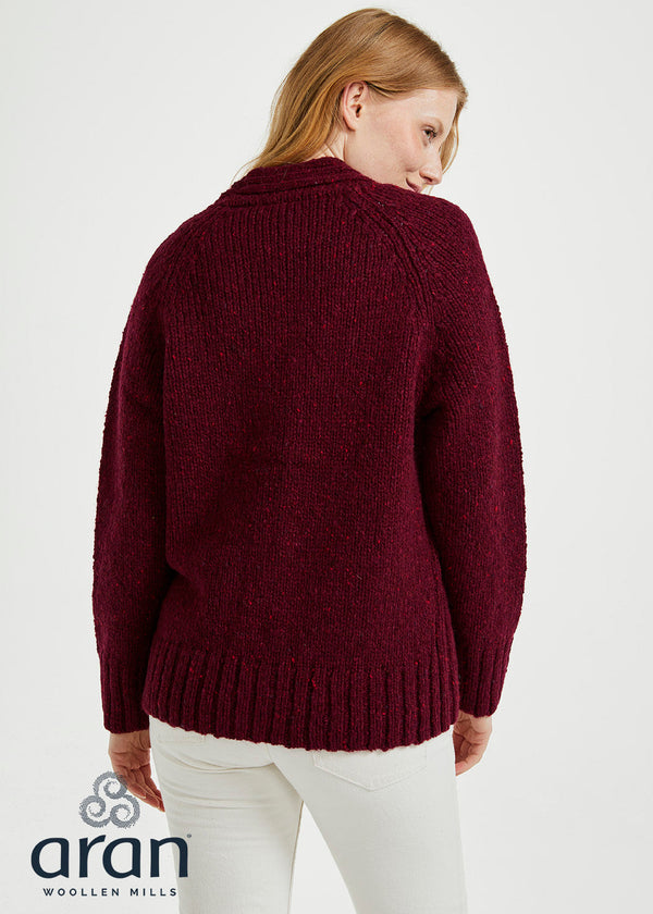 Woman wearing a burgundy sweater with 'Aran Woollen Mills' branding on a white background