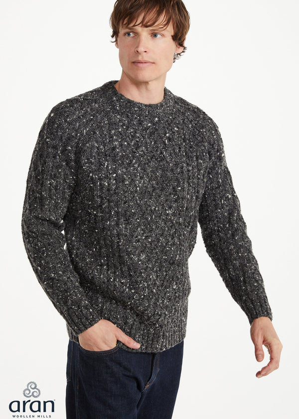 Man wearing a gray speckled sweater on a white background