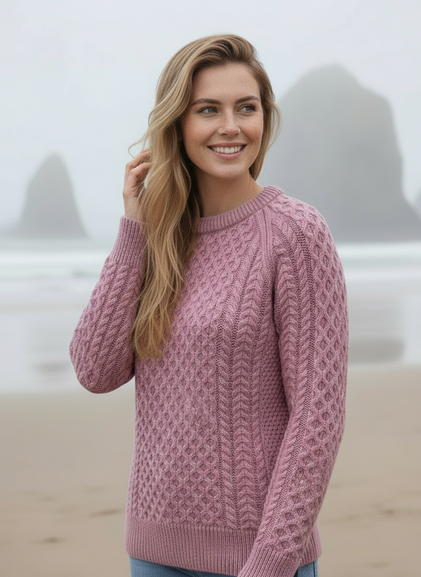 Woman wearing a pink sweater on a beach with blurred background