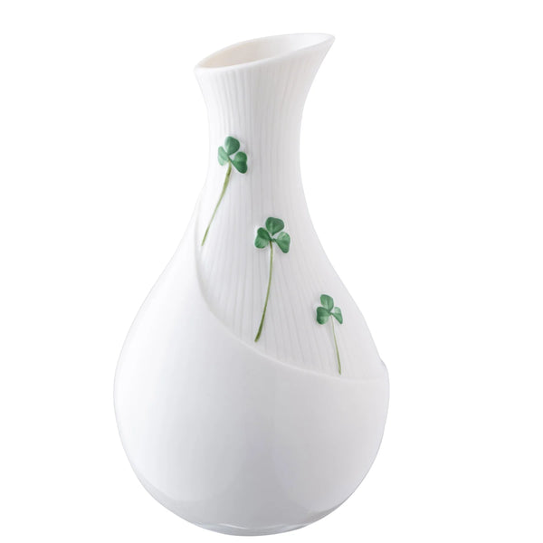 White vase with green clover designs on a white background