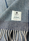 Close-up of a blue and white woven scarf with cream fringe and a visible McNutt of Toronto label.