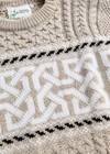 Close-up of a knitted sweater with a pattern and 'Original Design Co' label.