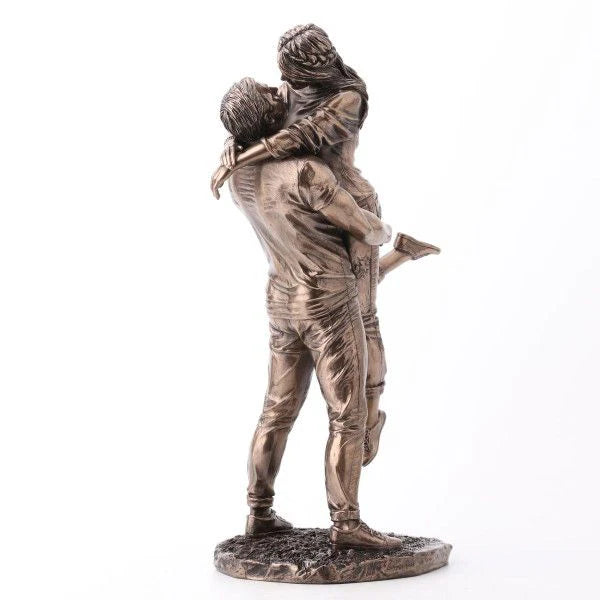 Bronze statue of a couple embracing on a white background