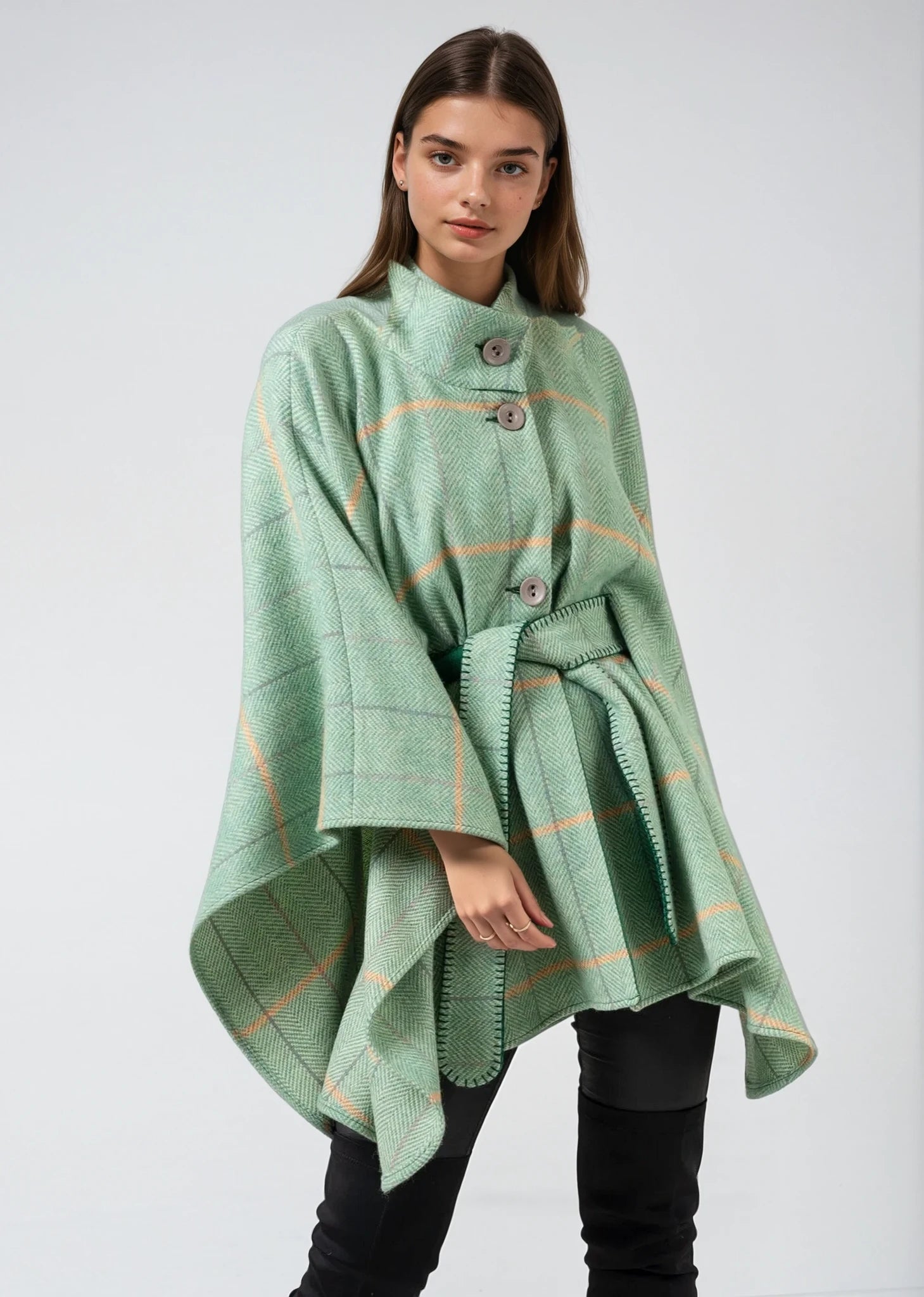 Woman wearing a Jimmy Hourihan green plaid poncho against a white background