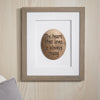 Framed wooden plaque with 'The heart that loves is always young' quote on a wooden wall.