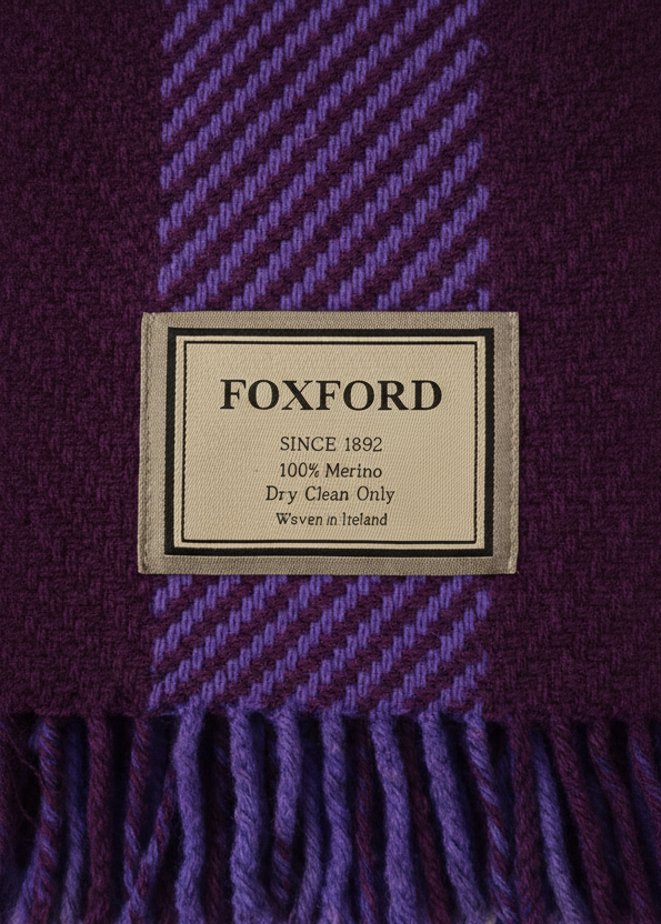 Close-up of a Foxford label on a purple and blue checkered fabric.