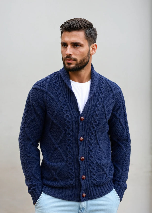Man wearing a blue knitted aran cardigan with brown buttons against a plain background