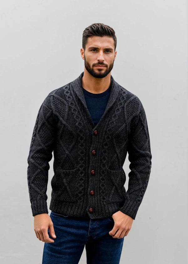 Man wearing a dark gray patterned aran cardigan with red buttons against a plain background