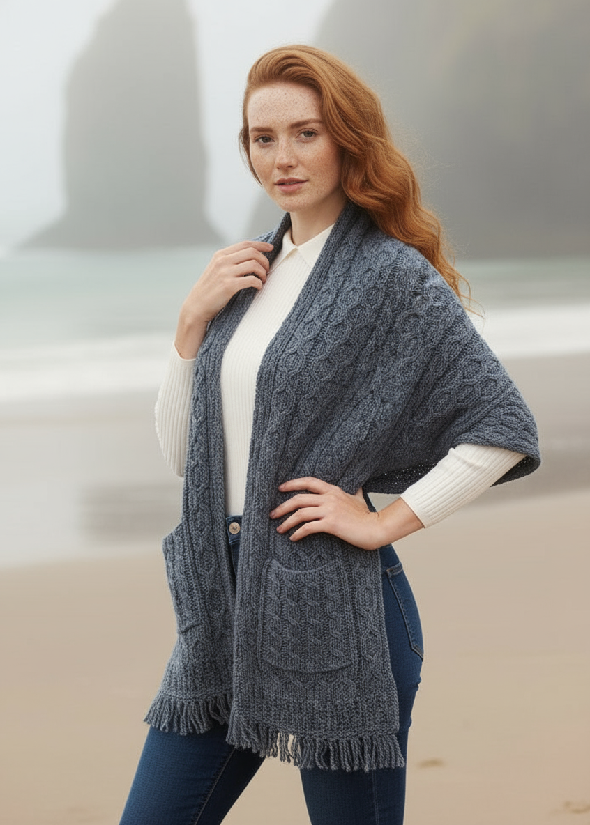 Woman wearing a blue knitted poncho against a neutral background