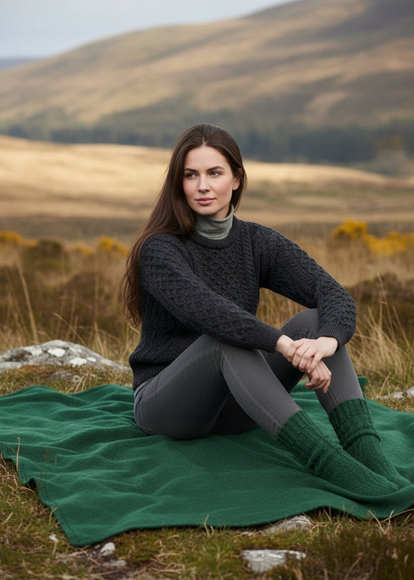 charcoal aran patterned sweater with a blurred natural background