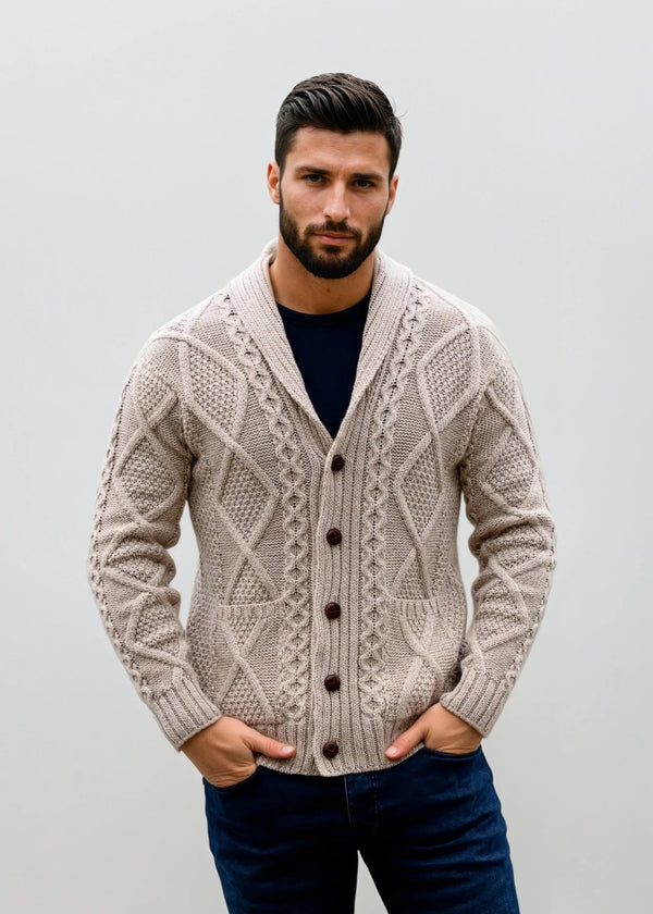 Man wearing a patterned beige aran cardigan against a plain background