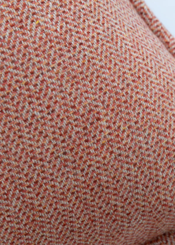 Close-up of a textured red-brown fabric with a subtle pattern on a white background
