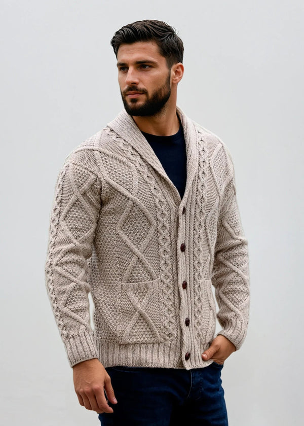 Man wearing a beige knitted aran cardigan against a plain background