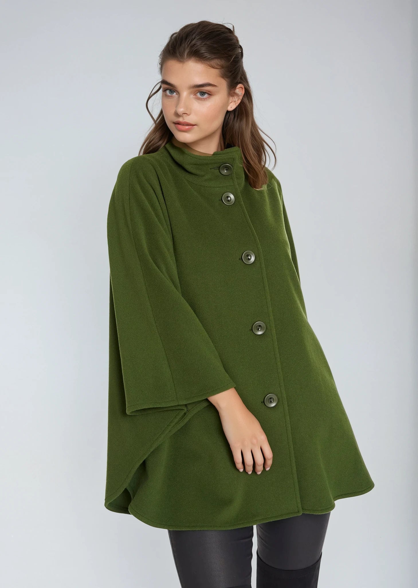 Woman wearing a green Jimmy Hourihan  cape coat against a white background
