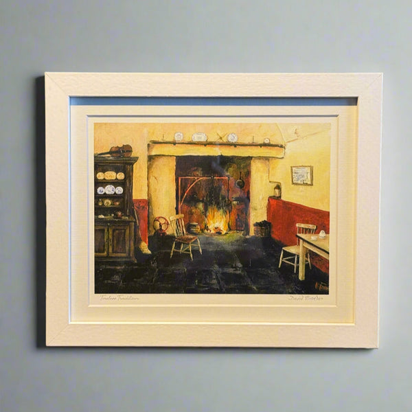 Framed artwork on a shelf with books and papers in the background