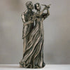 Bronze statue of a couple with a bird on a gray background