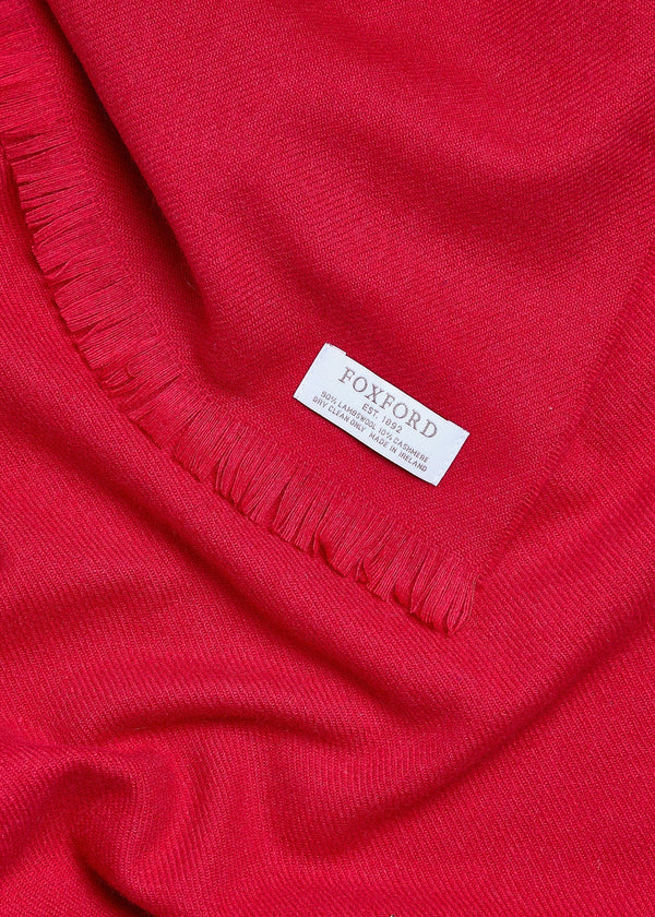 Close-up of a red fabric with a visible label on a plain background