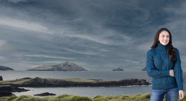 Woman standing on a coastal landscape with islands and a dark sky.