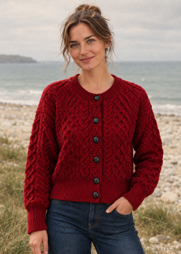 Front view, red Aran cardigan on a pebble beach under overcast skies