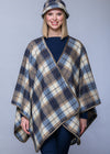 Person wearing a plaid poncho against a plain background